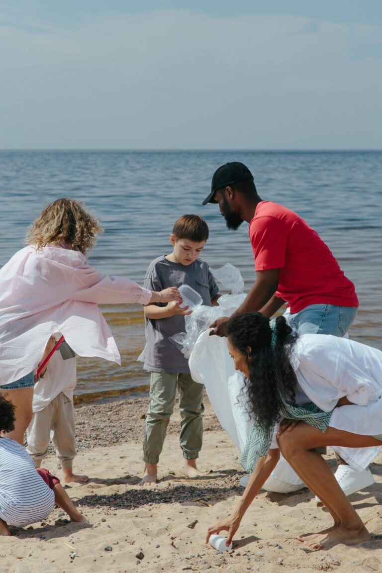 Freiwillige sammeln Plastikmüll am Strand ein. Foto: Pexels | Ron Lach