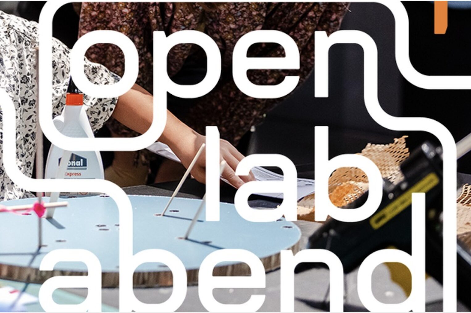 Schrift auf einem Foto mit Händen und Arbeitsmaterialien im Maker Space