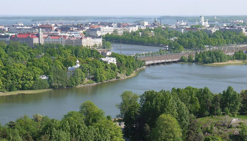Blick über Bäume und einen Fluss auf Helsinki.